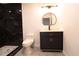 Well-lit bathroom featuring marble-tiled shower, a stylish modern mirror, and sleek black vanity at 69 N Hearn Rd, Ellenwood, GA 30294