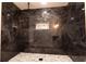Stylish, updated shower features dark marble-look tiling and mosaic flooring at 69 N Hearn Rd, Ellenwood, GA 30294