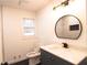 Bathroom with vanity, round mirror and stylish light fixture at 69 N Hearn Rd, Ellenwood, GA 30294
