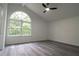 Bedroom featuring vaulted ceiling, ceiling fan, large arched window, and gray wood flooring at 69 N Hearn Rd, Ellenwood, GA 30294