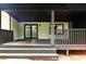 Inviting covered porch with a black ceiling, featuring painted brick walls and stylish railings at 69 N Hearn Rd, Ellenwood, GA 30294