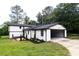 Side view of a two-story home featuring white brick and siding and an attached two-car garage at 69 N Hearn Rd, Ellenwood, GA 30294