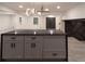 Open-concept kitchen with gray cabinets, black countertops, modern lighting, and an island for food preparation at 69 N Hearn Rd, Ellenwood, GA 30294