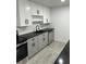Bright kitchen with white cabinets, black countertops, stainless steel appliances, and sleek modern hardware at 69 N Hearn Rd, Ellenwood, GA 30294