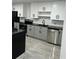 Bright kitchen featuring white cabinets, black countertops, stainless steel dishwasher, and modern fixtures at 69 N Hearn Rd, Ellenwood, GA 30294