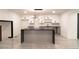 Open-concept kitchen with gray cabinets, black countertops, modern lighting, and an island for food preparation at 69 N Hearn Rd, Ellenwood, GA 30294