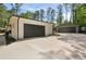 A two-car attached garage and detached garage, featuring dark garage doors and a newly paved driveway at 974 Clydesdale Dr, Marietta, GA 30062