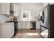 Bright kitchen features white cabinets, stainless steel appliances, and light wood floors at 974 Clydesdale Dr, Marietta, GA 30062