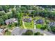 An aerial view of a red brick home outlined in yellow within a tree filled neighborhood at 189 Azalea Chase Dr, Suwanee, GA 30024