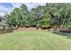 Large backyard featuring a lush lawn and mature trees, perfect for outdoor activities at 189 Azalea Chase Dr, Suwanee, GA 30024