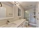Bright bathroom featuring double sinks, quartz countertops, and a glass-enclosed shower at 189 Azalea Chase Dr, Suwanee, GA 30024