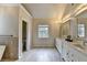 Elegant bathroom featuring double sinks, tiled floors and a separate tub with natural light at 189 Azalea Chase Dr, Suwanee, GA 30024