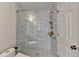 Bright shower boasts marble-look walls, glass door, and updated shower fixtures at 189 Azalea Chase Dr, Suwanee, GA 30024