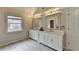 Spacious bathroom featuring double vanity with elegant mirrors and lighting fixtures with tile flooring at 189 Azalea Chase Dr, Suwanee, GA 30024