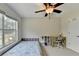Bedroom with plush carpet, ceiling fan, built-in shelf unit, and a built-in desk at 189 Azalea Chase Dr, Suwanee, GA 30024