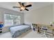 This bright bedroom features carpet, a ceiling fan, and a built-in desk at 189 Azalea Chase Dr, Suwanee, GA 30024