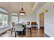 Dining area with hardwood floors, large windows, and modern lighting fixture at 189 Azalea Chase Dr, Suwanee, GA 30024