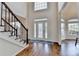 Welcoming foyer with hardwood floors, staircase with iron railings, and transom windows at 189 Azalea Chase Dr, Suwanee, GA 30024