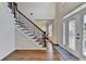 Bright foyer with hardwood floors, iron-spindled staircase, and decorative glass front door at 189 Azalea Chase Dr, Suwanee, GA 30024