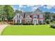 Beautiful brick home features manicured lawn, mature trees, and lovely landscaping at 189 Azalea Chase Dr, Suwanee, GA 30024