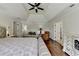 Open main bedroom with tray ceilings, wood floors, sitting area and a comfortable bed at 189 Azalea Chase Dr, Suwanee, GA 30024