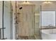 Close up of an elegant glass shower with stone accents and chrome shower head at 189 Azalea Chase Dr, Suwanee, GA 30024