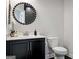Powder room features a modern vanity, decorative mirror, and a toilet at 247 Widener Way, Peachtree City, GA 30269