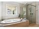 Modern bathroom featuring soaking tub, glass shower, and lots of natural light at 247 Widener Way, Peachtree City, GA 30269