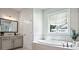 Bright bathroom features a soaking tub, window, and vanity with plenty of storage space at 247 Widener Way, Peachtree City, GA 30269