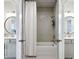 Bright bathroom with a shower-tub combo featuring gray tile surround, and double vanity sinks with round mirrors at 247 Widener Way, Peachtree City, GA 30269