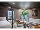 Well-lit bedroom with a large plant, seating area, two windows, and decoratively painted walls at 247 Widener Way, Peachtree City, GA 30269