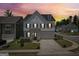 Two-story home with neutral gray exterior, black shutters and garage; manicured lawn; dusk sky at 247 Widener Way, Peachtree City, GA 30269