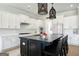 Modern kitchen featuring white cabinets, a black island with seating, and designer pendant lights at 247 Widener Way, Peachtree City, GA 30269