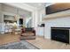 Open-concept living room with a stone fireplace, stylish decor, and a seamless transition to the kitchen at 247 Widener Way, Peachtree City, GA 30269