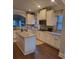 Kitchen with white cabinets, granite countertops, and an island with a view to the living area at 3675 Brookhollow Dr, Douglasville, GA 30135