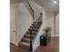 Stairway featuring carpeted steps, dark wood handrail and decorative iron spindles at 3675 Brookhollow Dr, Douglasville, GA 30135