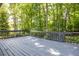 A view of the exterior back deck overlooking a vibrant wooded area with gray painted wood at 1172 Colony Dr, Marietta, GA 30068