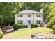Traditional home boasts a lush green lawn, complemented by mature trees, and a charming white picket fence at 1172 Colony Dr, Marietta, GA 30068