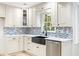 A bright kitchen has white cabinets, stone countertops, stainless appliances, and a black farmhouse sink at 1172 Colony Dr, Marietta, GA 30068