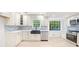 A bright eat-in kitchen features white cabinets, stainless appliances, and a backsplash to the ceiling at 1172 Colony Dr, Marietta, GA 30068