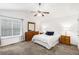 Cozy main bedroom with plush carpeting, neutral walls, ceiling fan, and a large window at 1902 Seals Rd, Dallas, GA 30157