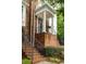 Brick townhome entrance with stairs leading to a columned porch at 2305 Limehurst Ne Dr # 21, Atlanta, GA 30319