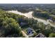 Aerial view of the estate with a house surrounded by trees and next to a lake, offering privacy at 5755 Riley Rd, Cumming, GA 30028