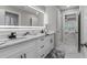 Sleek bathroom with a double sink vanity, marble countertops, and a modern, illuminated mirror at 5755 Riley Rd, Cumming, GA 30028
