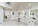 Bright bathroom featuring double vanities with marble countertops, and a large walk-in closet in the background at 5755 Riley Rd, Cumming, GA 30028