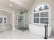 Well-lit bathroom featuring a soaking tub, glass shower, and marble throughout with plenty of room at 5755 Riley Rd, Cumming, GA 30028