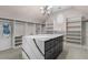 Spacious walk-in closet with custom shelving, a center island, and an elegant light fixture at 5755 Riley Rd, Cumming, GA 30028