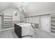 Spacious walk-in closet with custom shelving, a center island, and an elegant light fixture at 5755 Riley Rd, Cumming, GA 30028