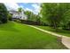 View of the back of a two-story home with a deck, set amongst a well-manicured lawn and retaining wall at 5755 Riley Rd, Cumming, GA 30028