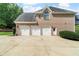 Spacious three-car garage with white doors and brick exterior, offering ample parking and storage space at 5755 Riley Rd, Cumming, GA 30028